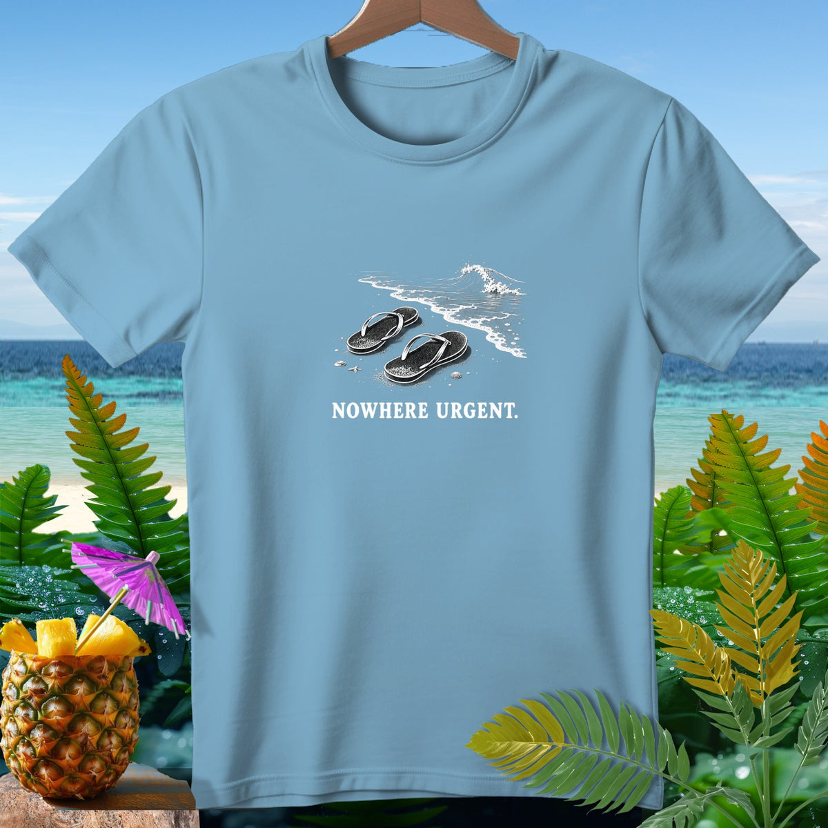 Light blue t-shirt with graphic of flip-flops on beach and text "NOWHERE URGENT."