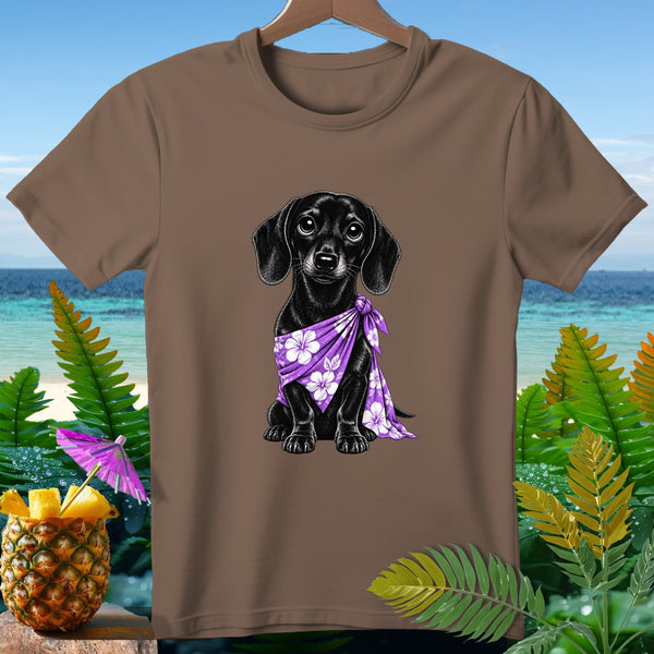 Black dachshund wearing purple floral bandana on brown t-shirt with tropical background.