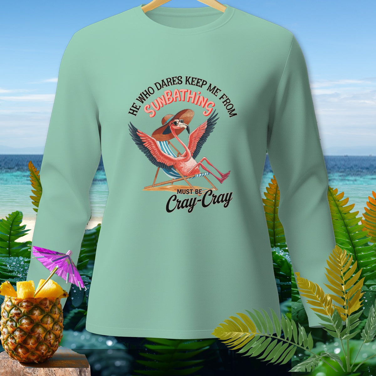 Mint long sleeve shirt with flamingo sunbathing graphic and text.