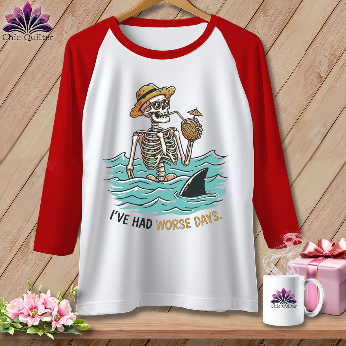 White t-shirt with red sleeves featuring a skeleton in the ocean with a shark fin and text "I've Had Worse Days."