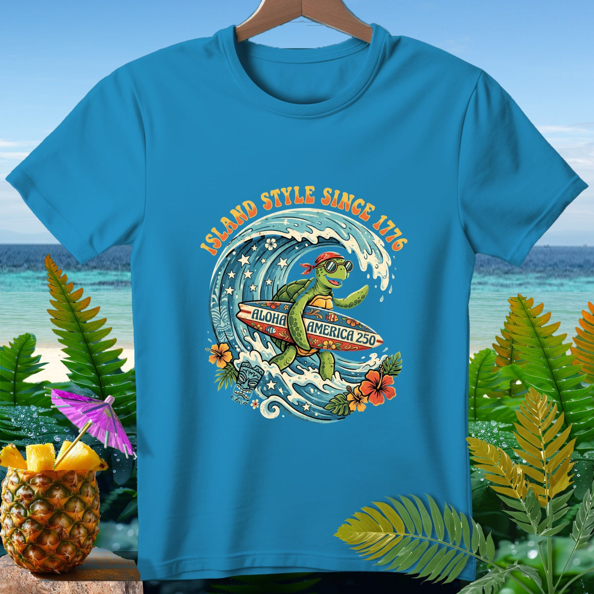 Blue t-shirt with cartoon turtle surfing a wave, "Island Style Since 1776 Aloha America 250"