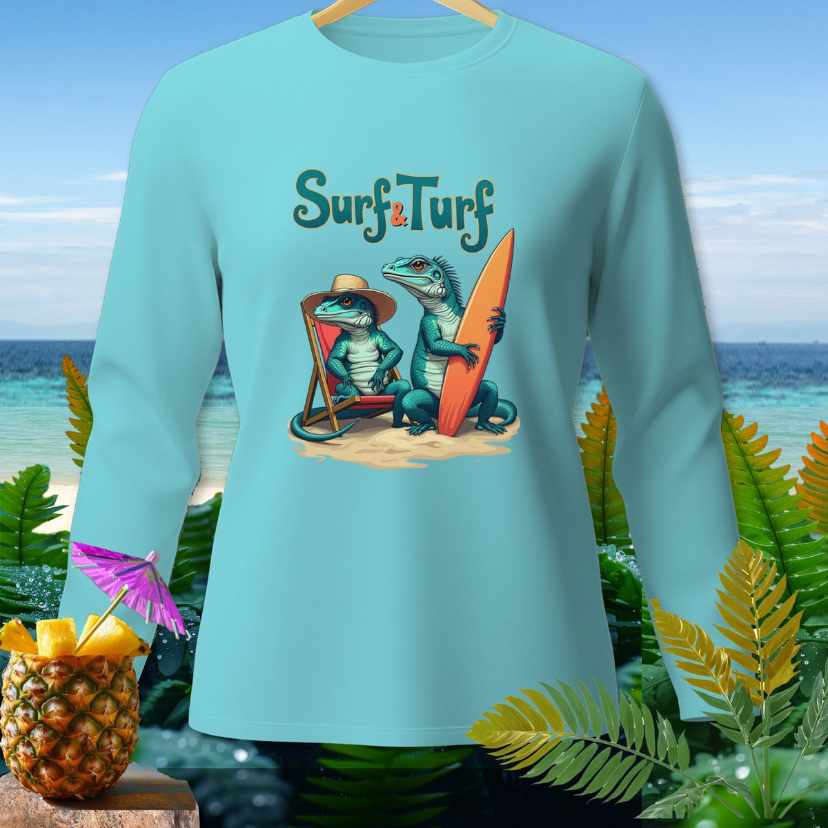 Light blue long-sleeved shirt with "Surf & Turf" text and two lizards with a surfboard on a beach.