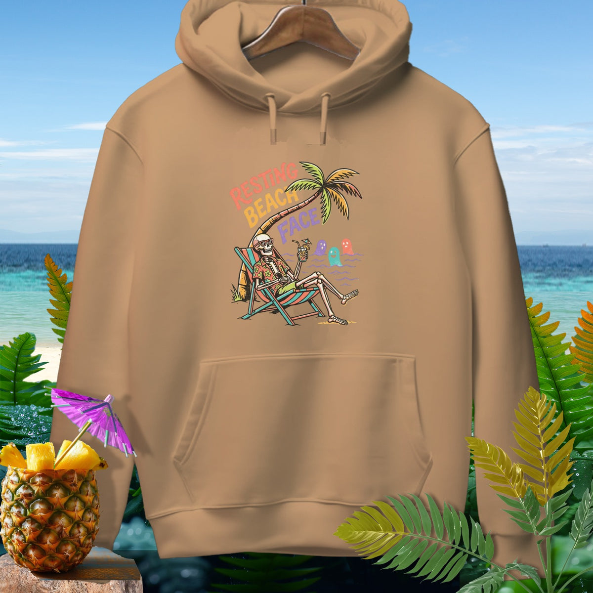 Tan hoodie with skeleton on beach chair graphic, text "Resting Beach Face".