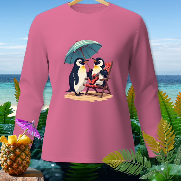 Pink long sleeve shirt with cartoon penguins under an umbrella on a beach.