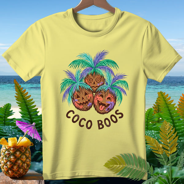 Yellow t-shirt with three jack-o-lantern coconuts under palm trees, reading "Coco Boos".