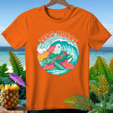 Orange t-shirt with a graphic of a turtle and ghost surfing on a wave, text 