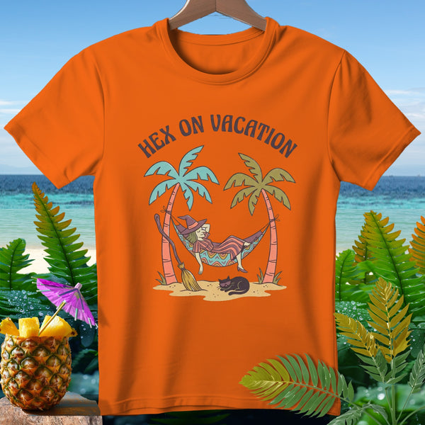 Orange t-shirt with a witch relaxing in a hammock with text "Hex on Vacation".