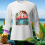 White long-sleeve shirt with graphic of two flamingos at a beach bar.