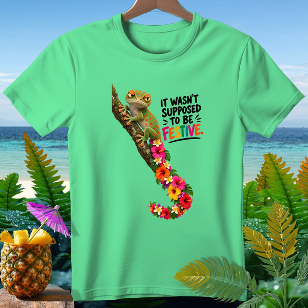 Green t-shirt with a gecko and text "IT WASN'T SUPPOSED TO BE FESTIVE."