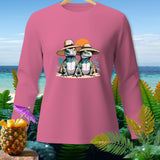 Pink long-sleeved shirt featuring two cartoon lizards wearing straw hats on a beach.