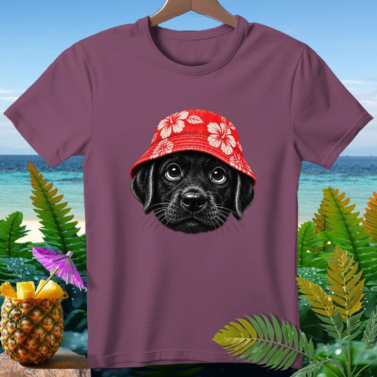 Black puppy wearing a red floral bucket hat on a plum t-shirt.