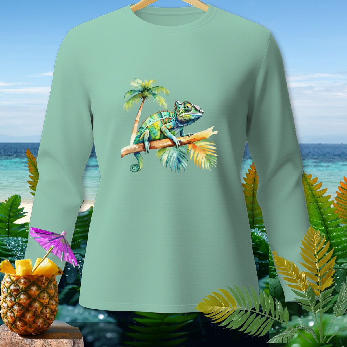 Light green long-sleeve shirt with a watercolor chameleon on a branch and tropical background.