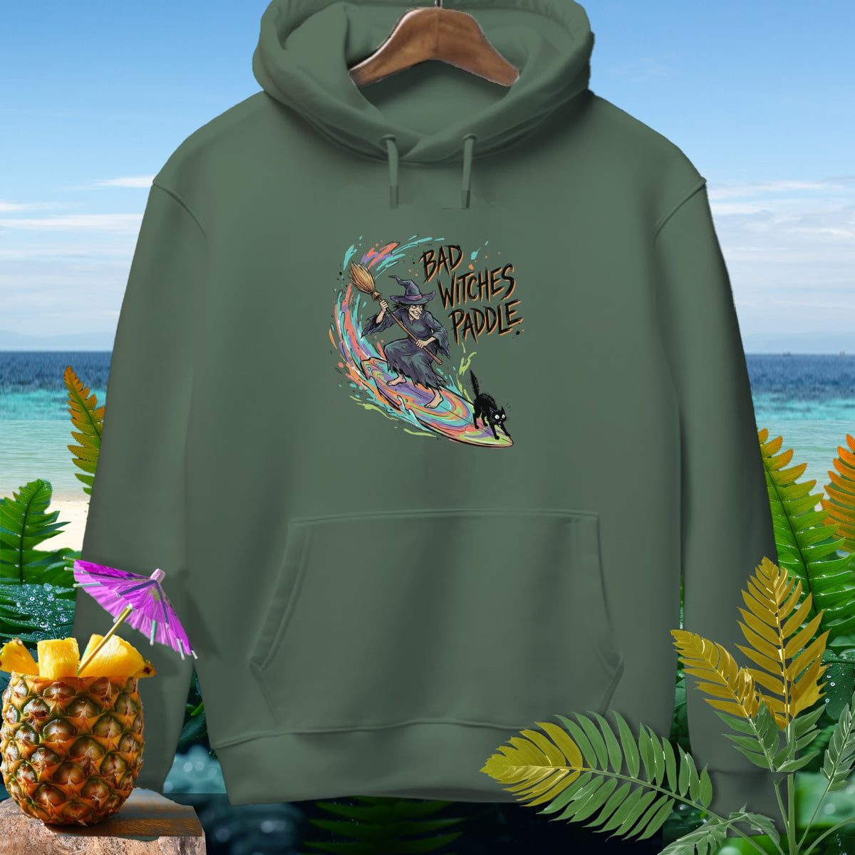 Green hoodie with a graphic of a witch, black cat, and "Bad Witches Paddle" text.