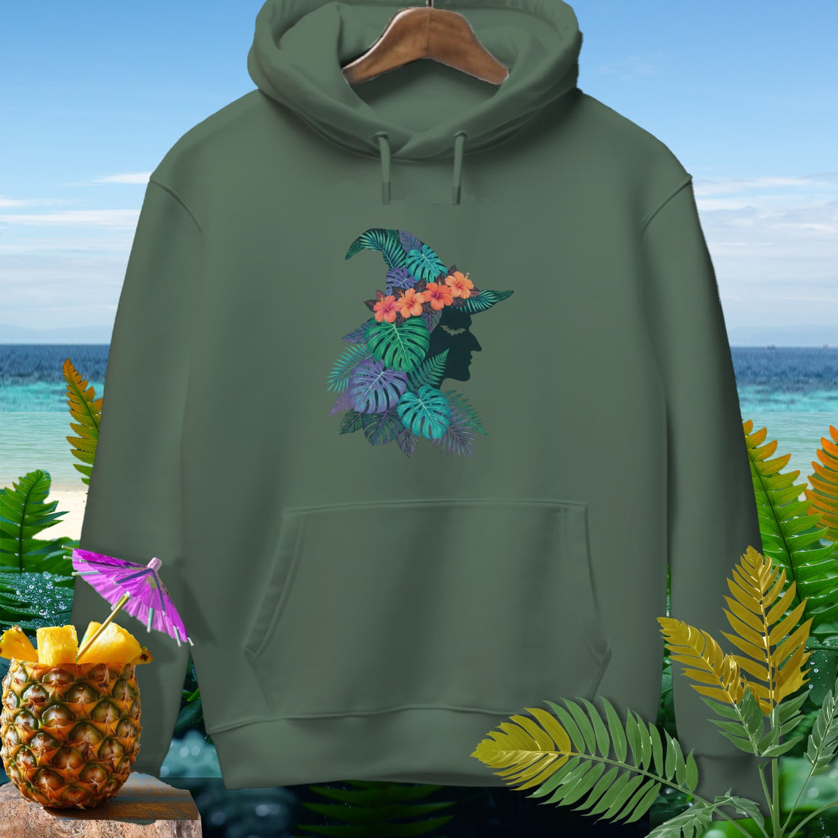 Olive green hoodie with tropical witch silhouette graphic and pineapple garnish.