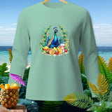 Light teal long-sleeve shirt with a peacock and fruit graphic, set against a beach backdrop.