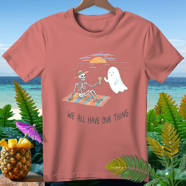 T-shirt with skeleton and ghost on beach with text "We all have our thing."