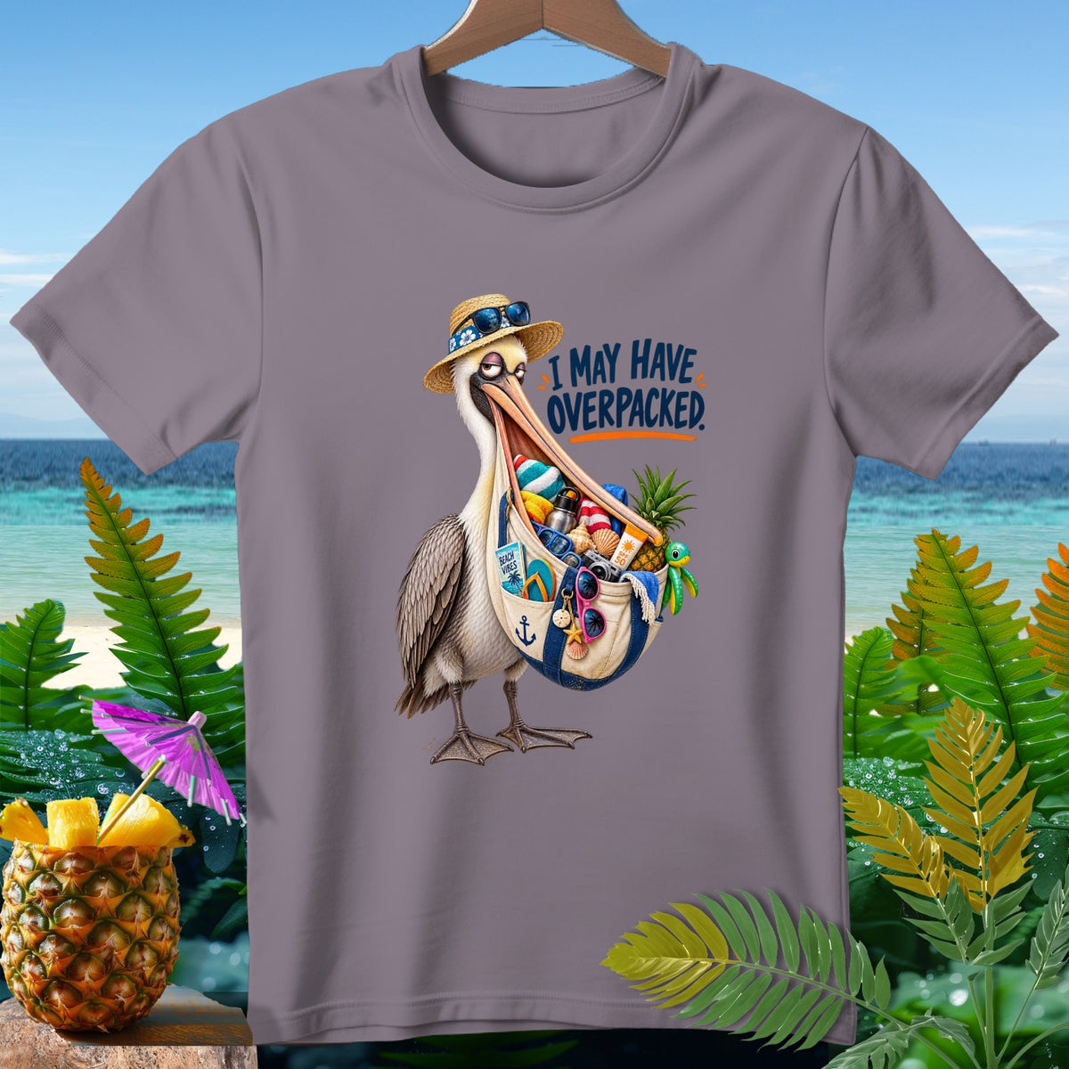Gray t-shirt with a pelican stuffed with beach items and the text "I MAY HAVE OVERPACKED."