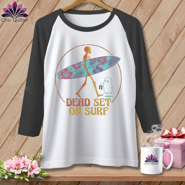 White baseball tee with skeleton carrying a floral surfboard and ghost, text "DEAD SET ON SURF."