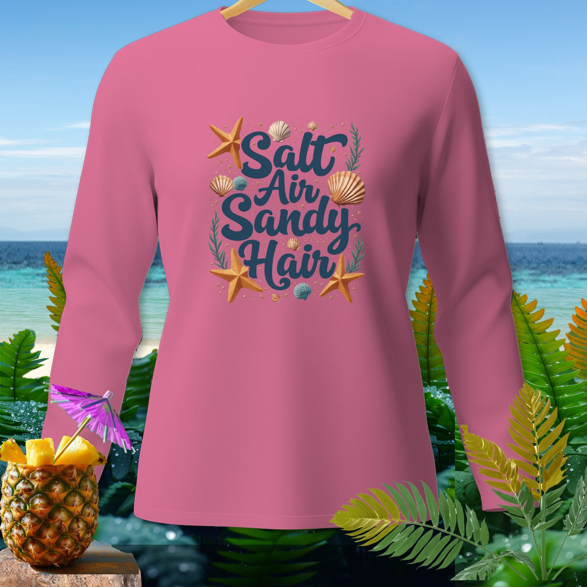 Pink long-sleeve shirt with "Salt Air Sandy Hair" graphic, starfish, and seashells.
