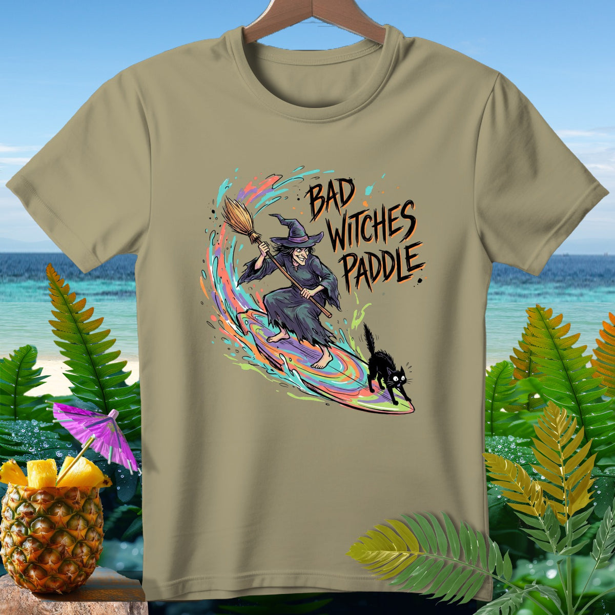 Witch and cat surfing a rainbow wave with text "Bad Witches Paddle".