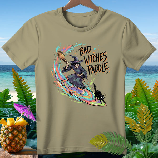 Witch and cat surfing a rainbow wave with text "Bad Witches Paddle".