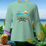 Light green long-sleeve shirt with a turtle, beach chairs, and sunset graphic.