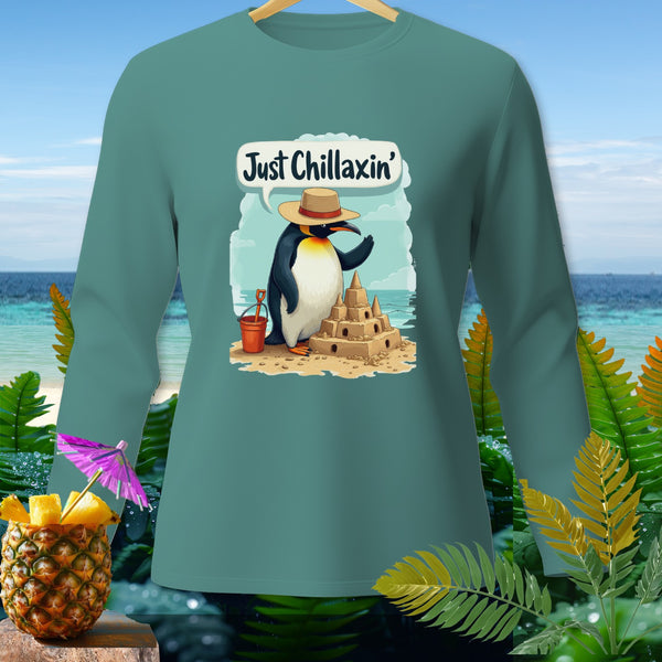 Penguin building sandcastle on beach, with text "Just Chillaxin'" and tropical background.