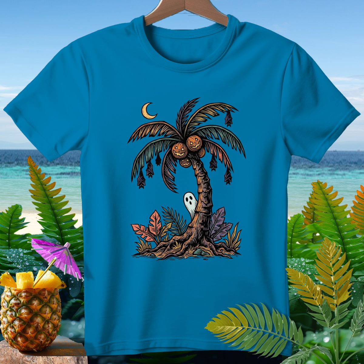 Turquoise t-shirt with Halloween palm tree graphic, bats, ghost, and pumpkins.
