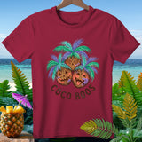 Burgundy t-shirt with three carved pumpkins under palm trees, text reads 