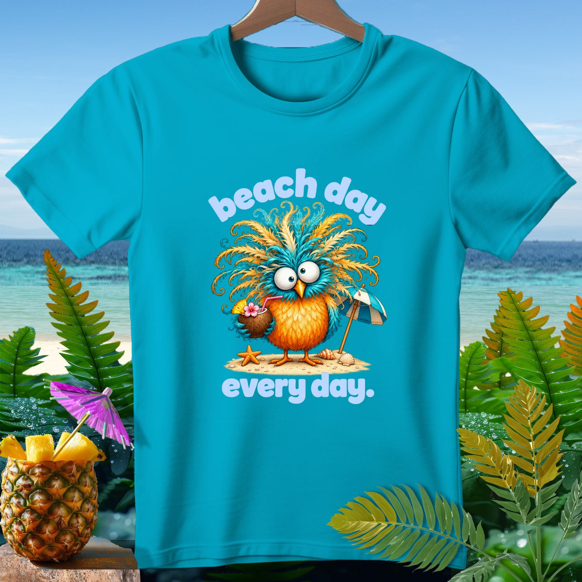 Turquoise t-shirt with cartoon bird holding a coconut drink, saying "beach day every day."