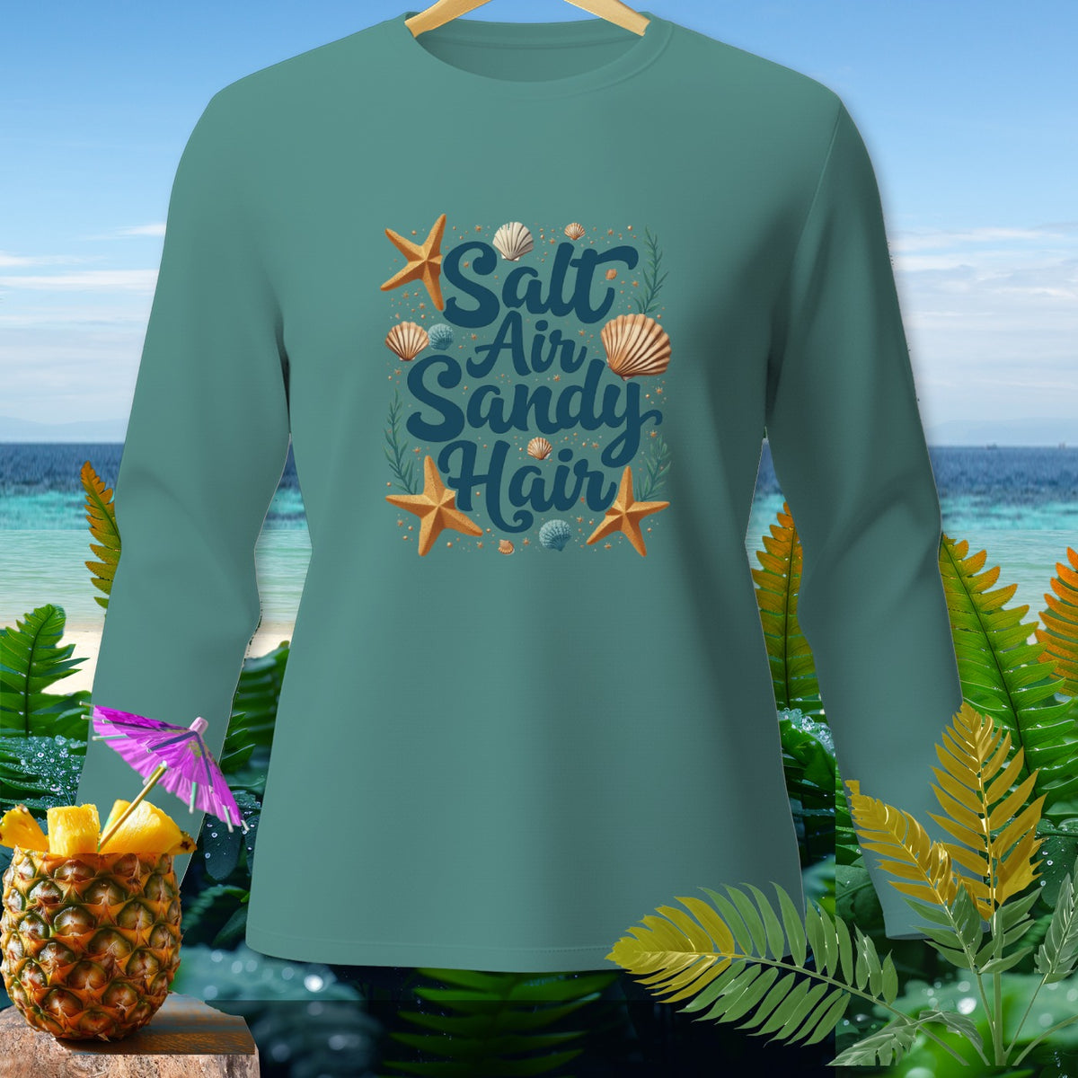 Teal long-sleeve shirt with "Salt Air Sandy Hair" text and beach motifs.