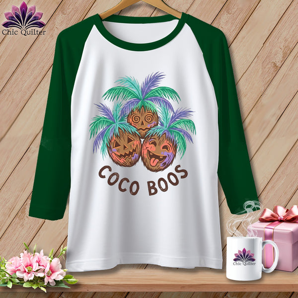 White baseball tee with "Coco Boos" and three jack-o'-lantern coconuts with palm fronds.