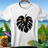 White t-shirt with a black monstera leaf graphic and tropical background.