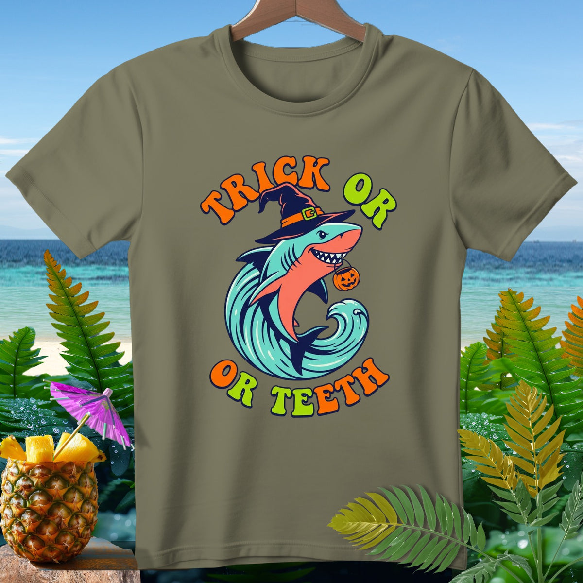 Shark with witch hat and pumpkin trick or teeth Halloween graphic on a tan t-shirt.
