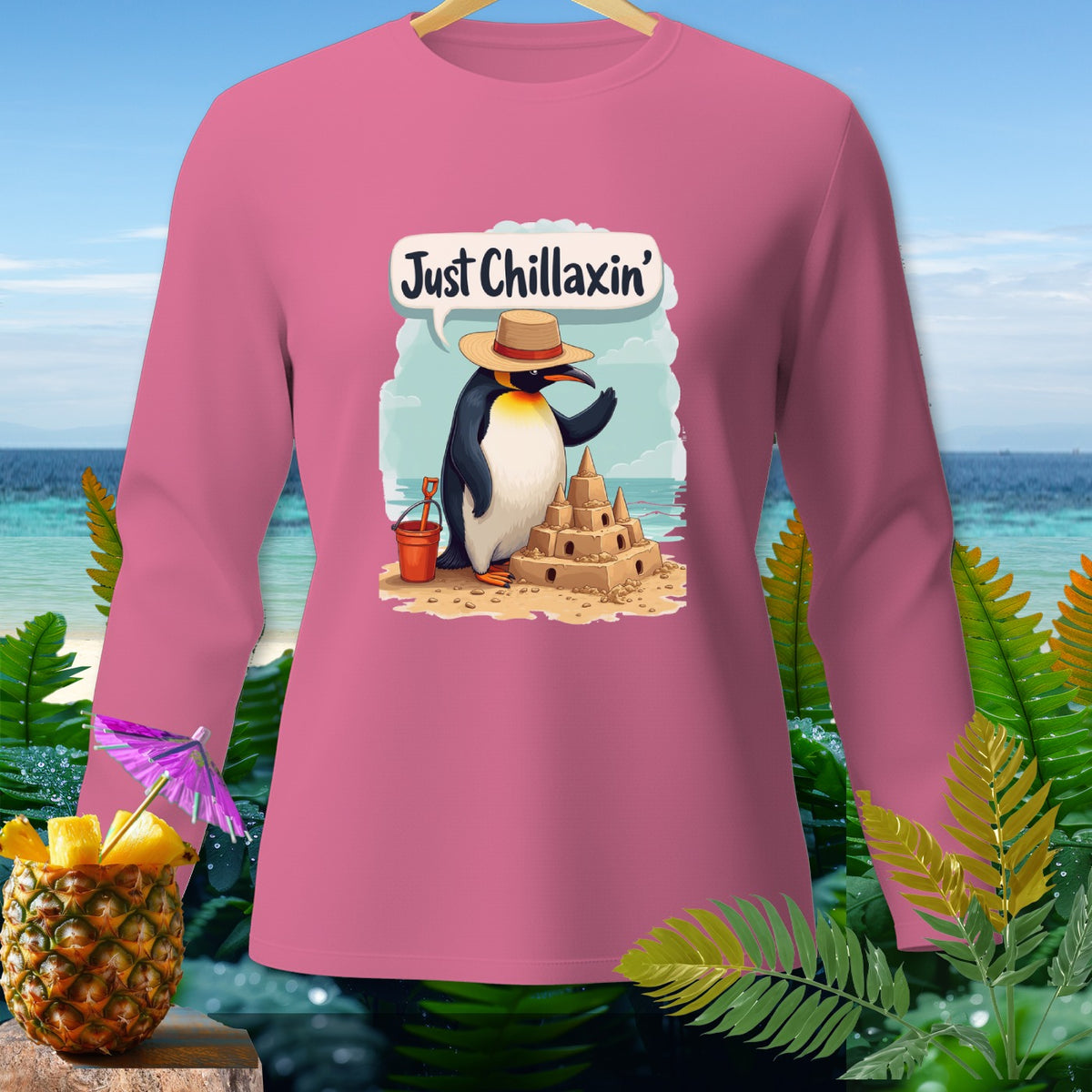 Pink long sleeve shirt with a penguin building a sandcastle and the text "Just Chillaxin'".