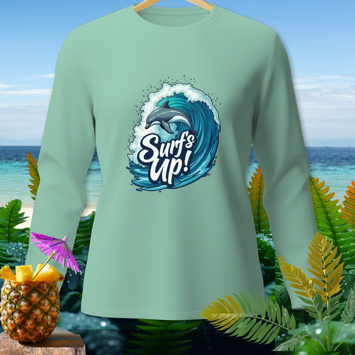 Mint green long-sleeve shirt with a dolphin surfing a wave and "Surf's Up!" text.