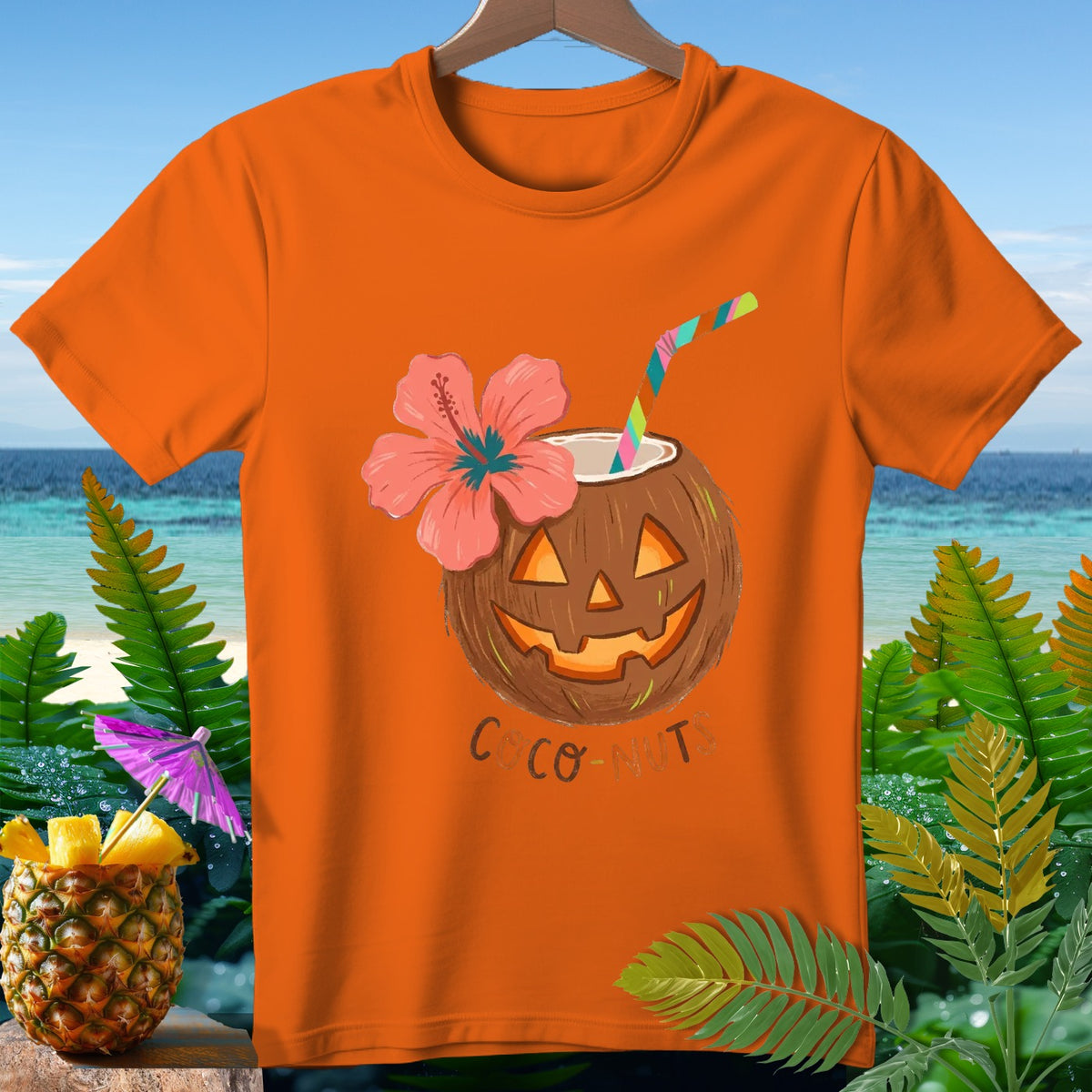 Orange t-shirt with jack-o'-lantern coconut drink, hibiscus flower, straw, and text "COCO-NUTS".