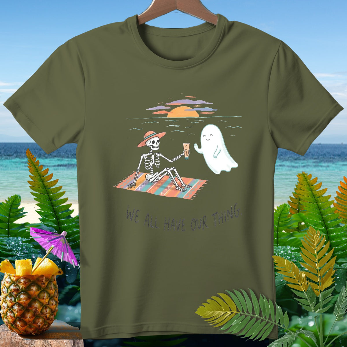 Skeleton and ghost on a beach blanket with text "WE ALL HAVE OUR THING".