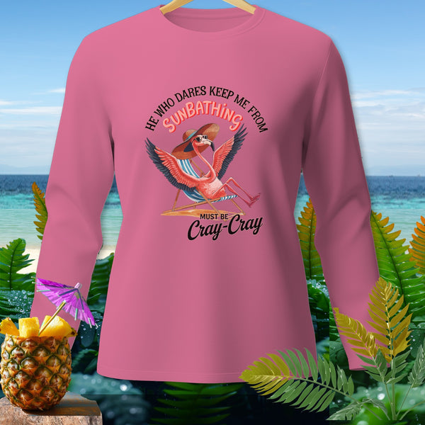 Pink long-sleeve shirt with a graphic of a flamingo sunbathing and the text "He who dares keep me from sunbathing must be cray-cray".