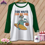 White t-shirt with green sleeves featuring a skeleton holding a surfboard and pumpkin.