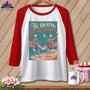 White baseball tee with a graphic of skeletons dancing on a beach with text "Til Death Do Us Party."
