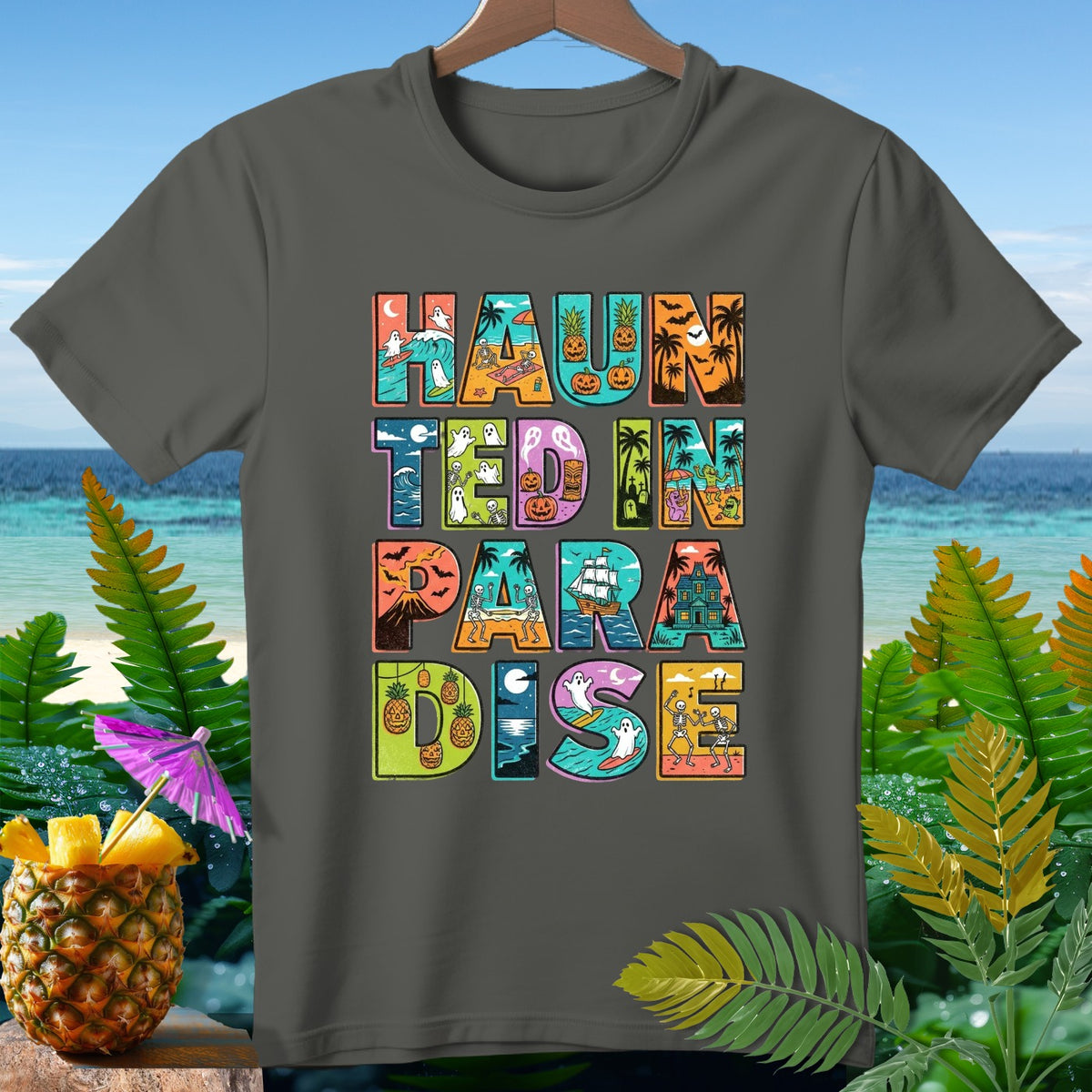 "Haunted in Paradise" text with Halloween beach scenes on a dark gray t-shirt.