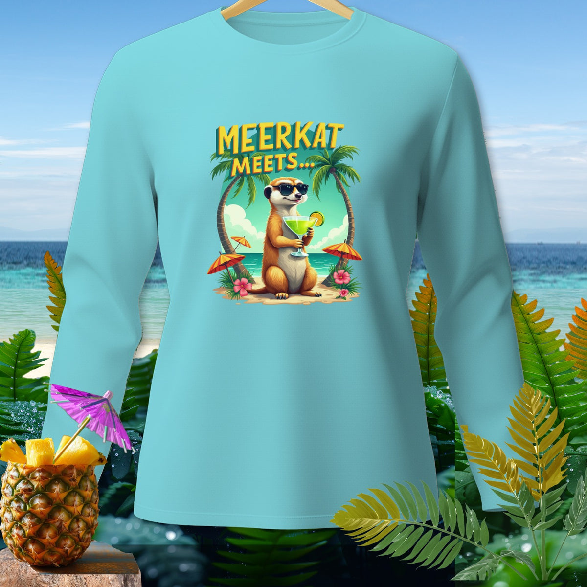 Light blue long-sleeve shirt with a meerkat holding a drink on a beach.