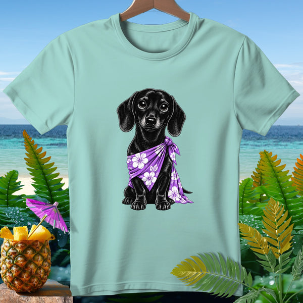 Black dachshund wearing purple floral bandana on light blue t-shirt with tropical background.