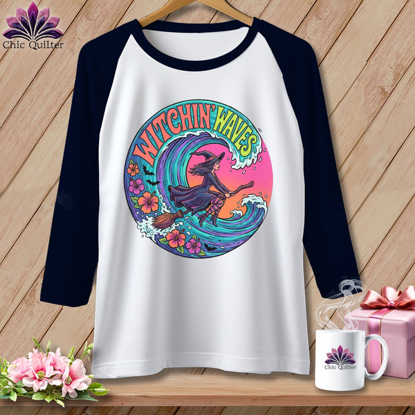 White baseball tee with a witch flying on a broomstick over waves.