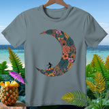 Gray t-shirt with a crescent moon design of tropical foliage and a surfer.