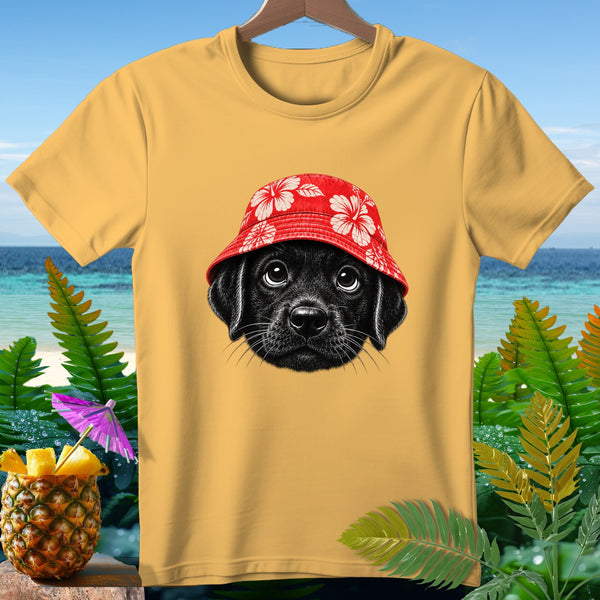 Black puppy wearing a red floral bucket hat on a yellow t-shirt.