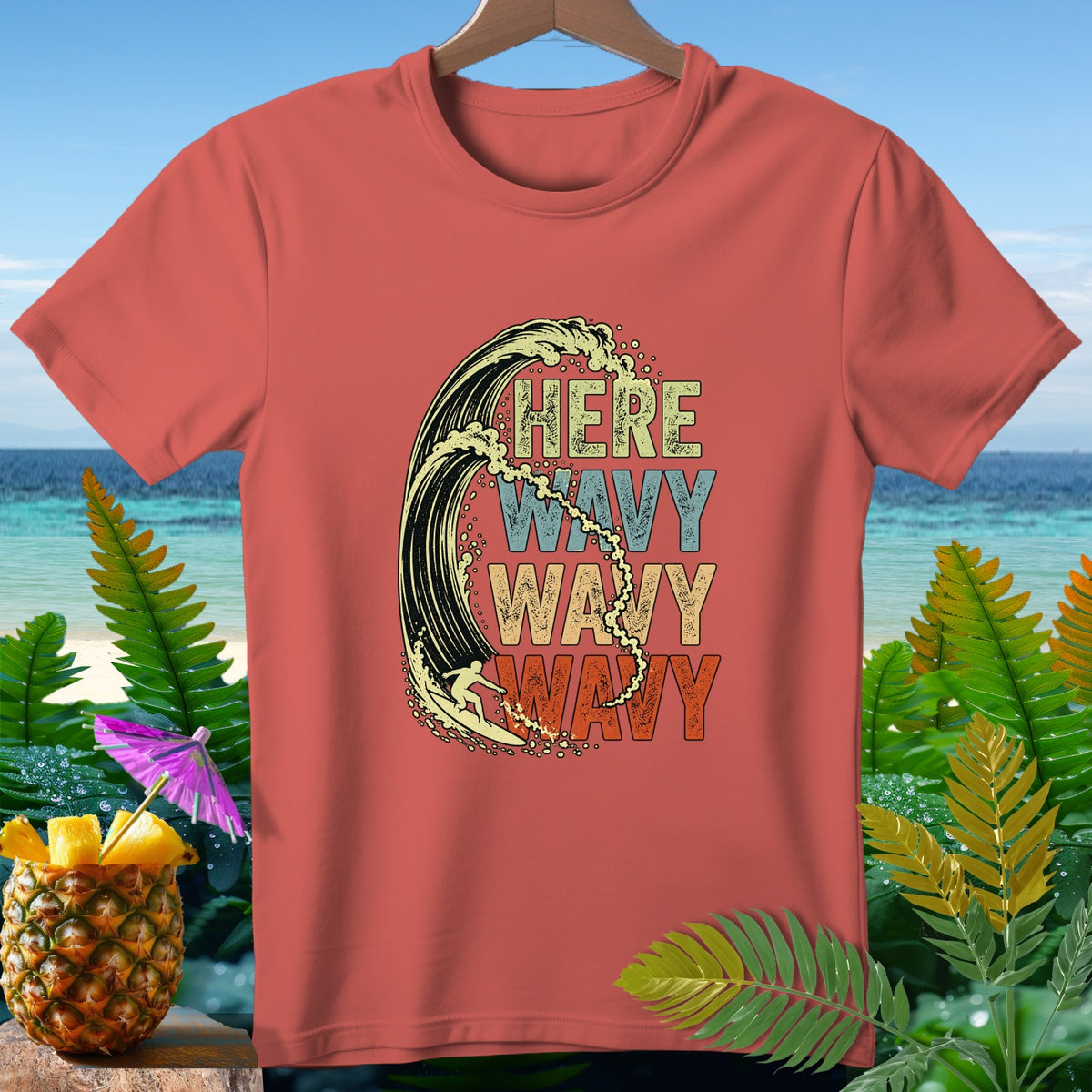 Salmon t-shirt with surfer riding a wave and text "HERE WAVY WAVY WAVY".