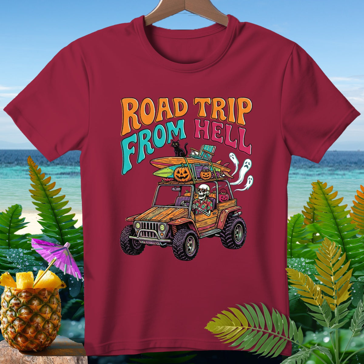 T-shirt graphic with skeleton in jeep, pumpkins, surfboards, and "Road Trip From Hell" text.