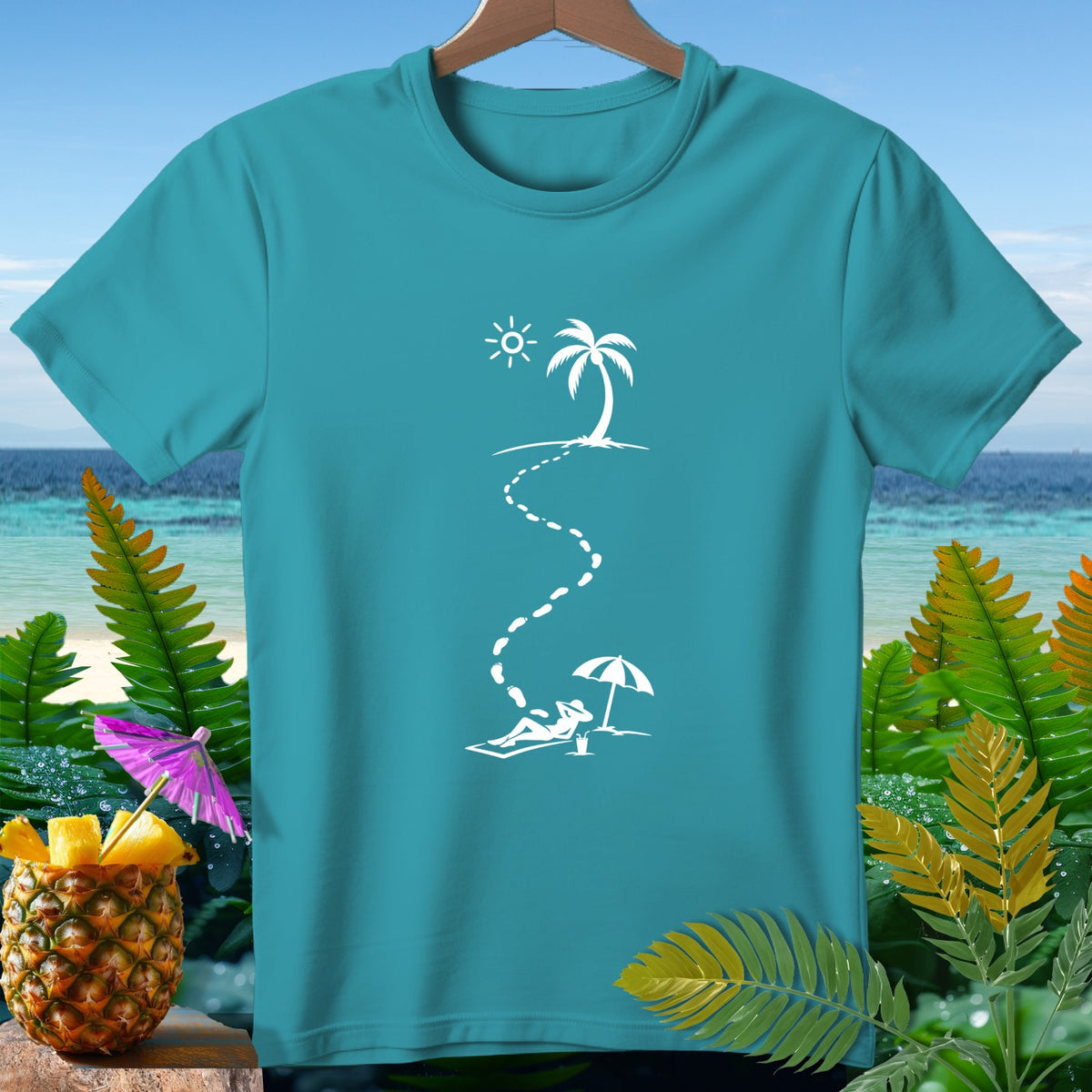 Teal t-shirt with white graphic of a person relaxing under an umbrella on a beach.